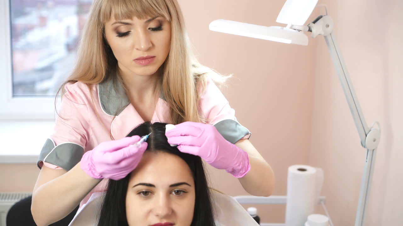 Handsome woman receives an injection in the head. The concept of mesotherapy. Thrust to strengthen the hair and their growth. Work of the cosmetologist