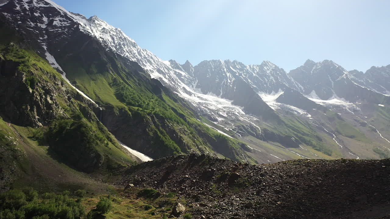파키스탄의 날타르 계곡에서 구름을 통해 들어오는 산 계곡과 태양 광선의 드론 샷, 영화 같은 드론 샷