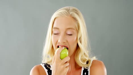 portrait of beautiful woman eating green apple