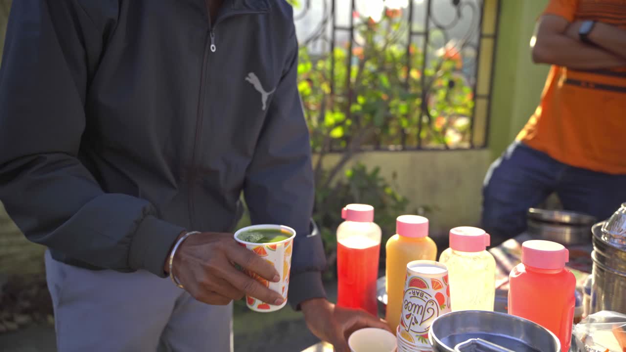 tomada de cerca de hombres con las manos mezclando lilas indias frescas, jugo de neem fuera del parque público, pune, india