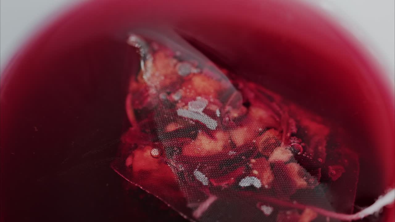 Close up of a fruit tea bag in a white cup