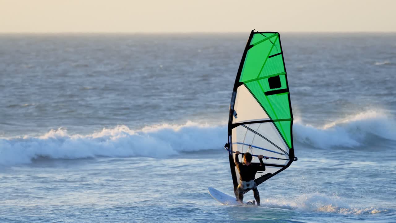 surfista masculino haciendo windsurf en la playa 4k