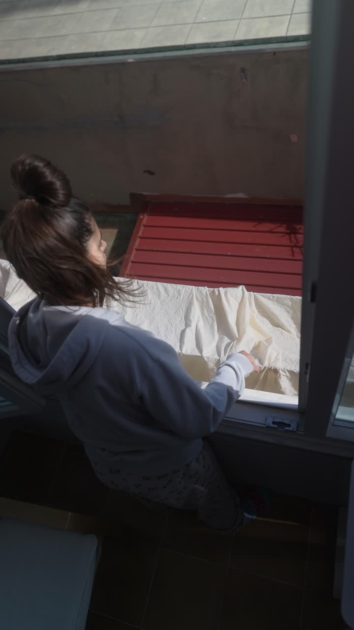 Woman Drying Clothes on Balcony