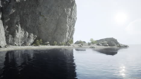 tranquil beach scene with a cliff and reflections in the water