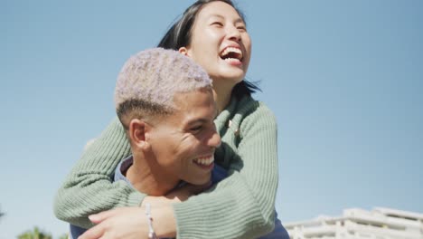 Happy-biracial-couple-embracing-on-promenade,-in-slow-motion