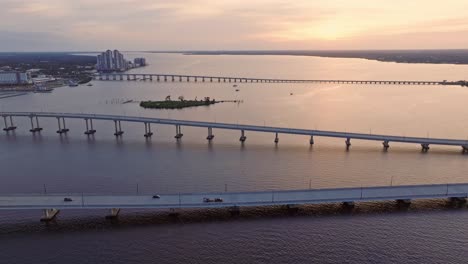 Vista-Aérea-Hacia-Atrás-Del-Puente-De-Fort-Myers-Sobre-El-Océano-En-Florida,-EE.UU.