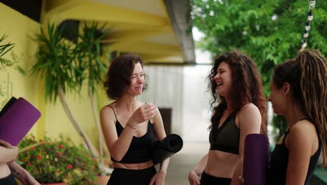 concepto de acondicionamiento físico, deporte y estilo de vida saludable - grupo de mujeres con esteras en un estudio de yoga al aire libre