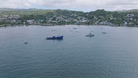 Aerial-approching-shot-of-Bahia-De-Samana-with-anchored-boats-and-ships-during-cloudy-day