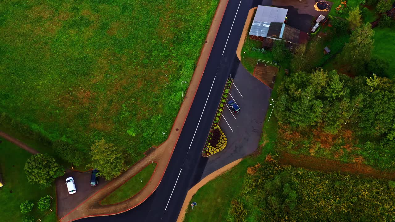 Freshly paved road with new parking area and surrounding green fields in rural setting