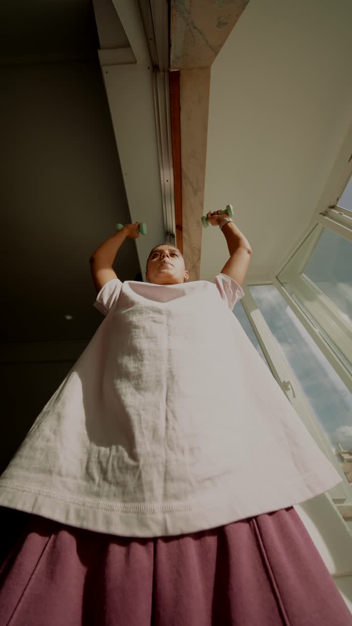 집에서 아령으로 운동하는 여성