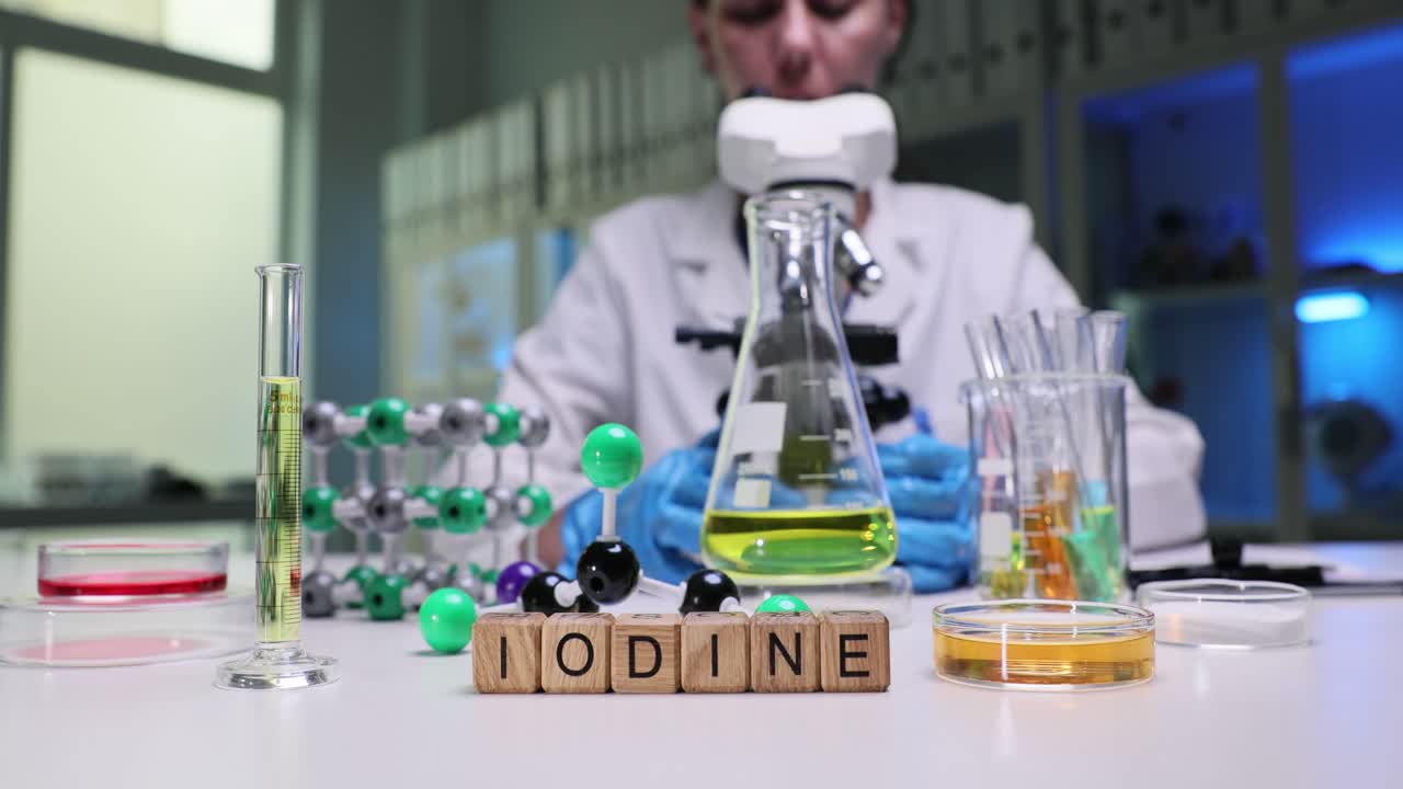 Scientist Working with Microscope in a Chemical Laboratory with Iodine