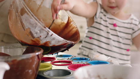 niña feliz ayudando a su madre a hornear en la cocina vertiendo masa en la bandeja de hornear preparando receta de pastel casero en casa