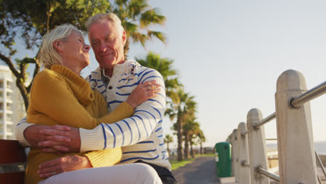 Senior-couple-embracing-each-other-alongside-beach