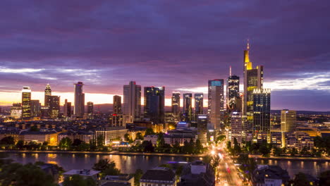 Antena:-Día-A-Noche-Hiper-Lapso-/-Lapso-De-Tiempo-De-Movimiento-De-Frankfurt-Am-Main-Alemania-Vista-Del-Horizonte-Y-Hermosas-Luces-De-La-Ciudad-Con-El-Río-Principal-En-Primer-Plano