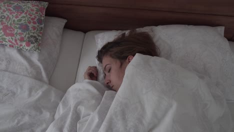 vista de arriba hacia abajo de la niña dormida en la cama, movimiento de cámara deslizante
