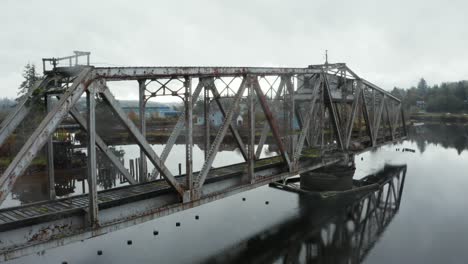 Orbit-of-moss-covered-old-swing-bridge-in-the-middle-of-foggy-lake