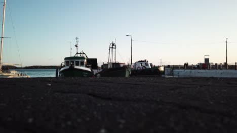 boats moored in an irish harbor during a sunset, close to the ground