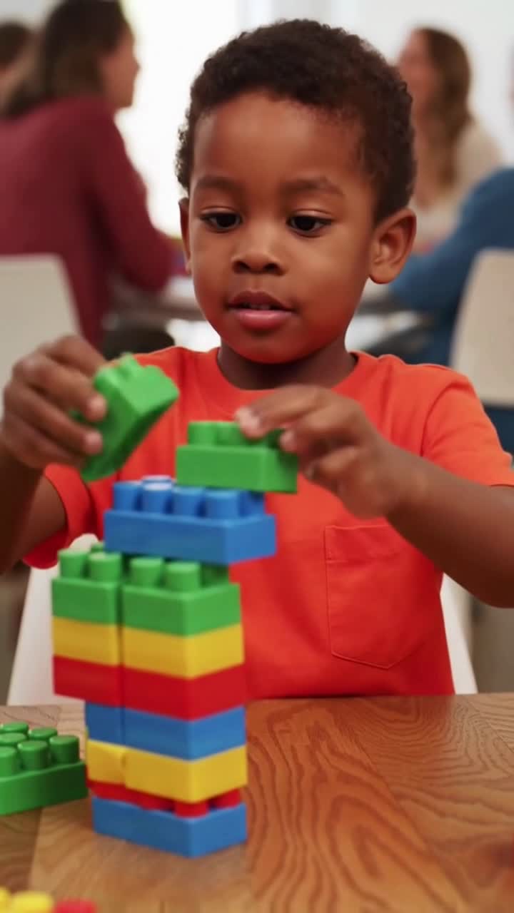 Young boy concentrating while playing with colorful building blocks at school