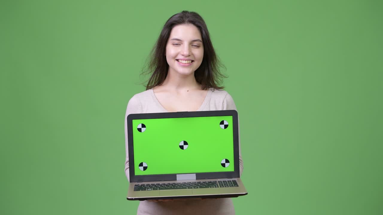 Young beautiful woman thinking while showing laptop