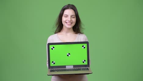 young beautiful woman thinking while showing laptop