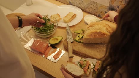 una pareja enamorada haciendo un sándwich en la cocina de la sala de estar