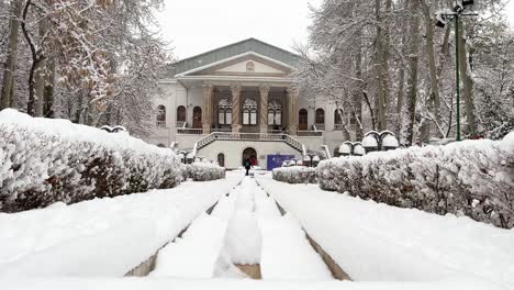 Perspectiva-Simétrica-Invierno-Nieve-Blanca-Casa-Palacio-En-Teherán-Cálido-Blanco-Rosa-Espiral-Diseño-Arquitectónico-Columna-Vista-Amplia-Pabellón-En-Un-Edificio-Histórico-En-Irán-Piscina-Con-Fuente-De-Piedra-árboles-Viejos