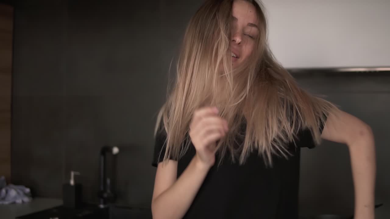 la chica baila más libremente en la cocina con un moderno interior de desván