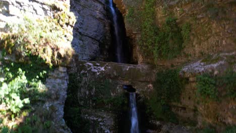 beautiful waterfall hidden inside canyon carved by water falling from mountains in albania