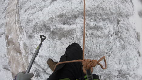 a crystal seeker mountaineer climbs a mountain and crosses a crevasse in a glacier in the swiss alps with his equipment, pickaxe, rope