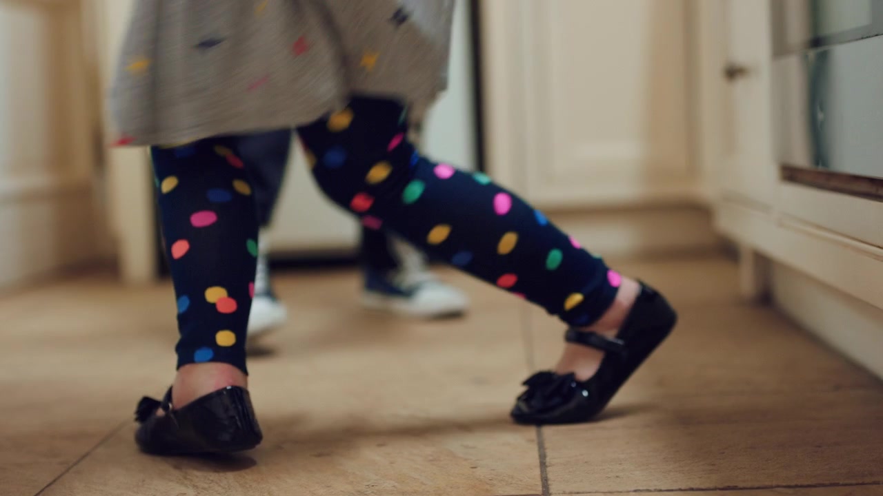 Young Child Dancing in Kitchen with Parent