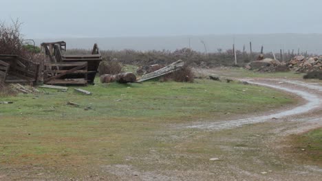 Young-lonely-man-walks-on-uninhabited-rural-area-in-Europe-on-a-rainy-grey-day