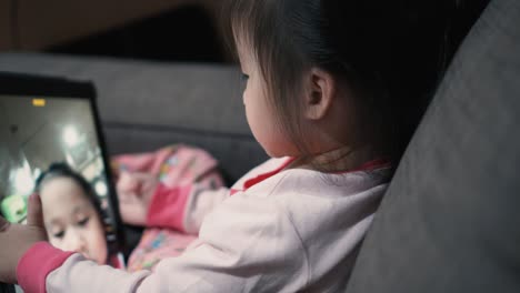 little girl using digital tablet and taking selfie