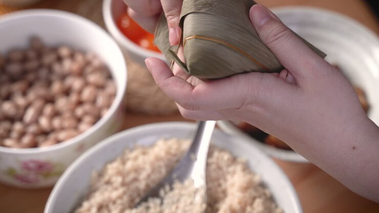Making zongzi food - preparing and wrapping Chinese rice dumpling.