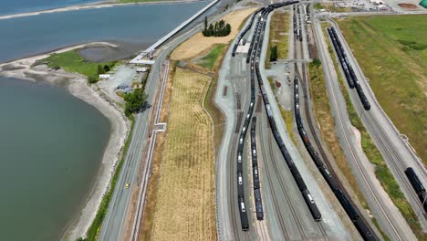 aerial shot of a train depot next to an oil refinery