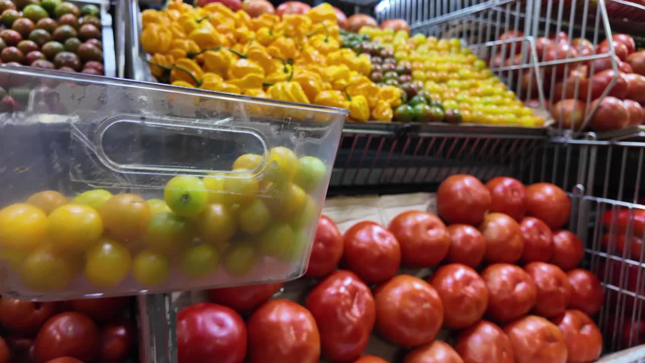 Plano com zoom de vegetais frescos em um mercado de produtos, pimentões coloridos, pimentas malaguetas (ajies) e tomates expostos juntos, cena de mercado local e comida saudável vibrante