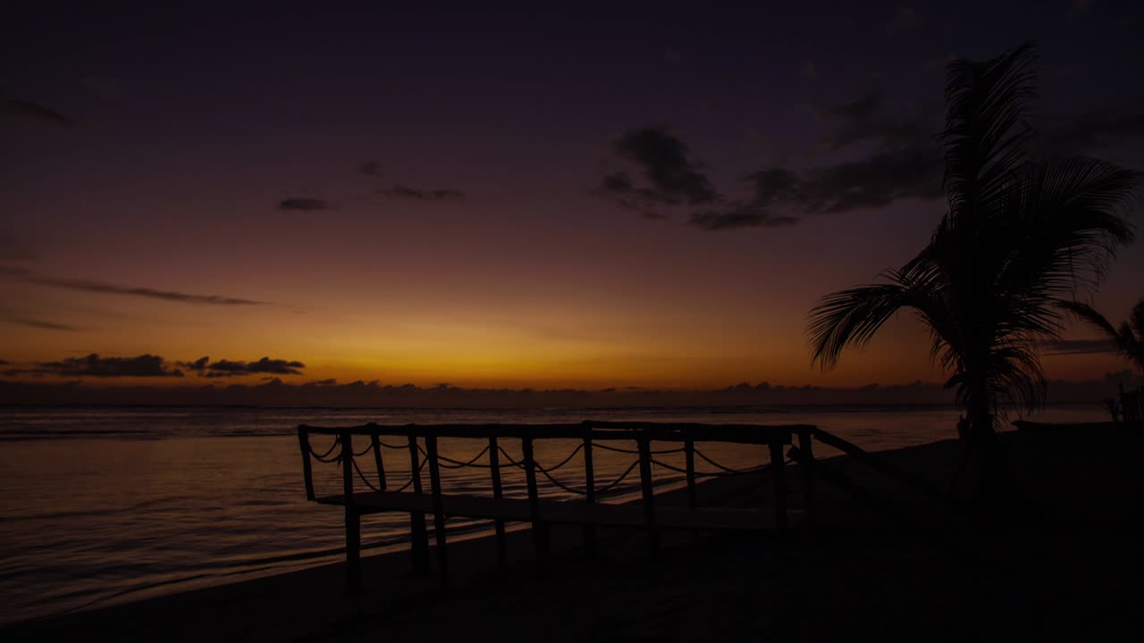 Pont en bois et palmier sur la plage près de l'océan, timelapse de lever de soleil