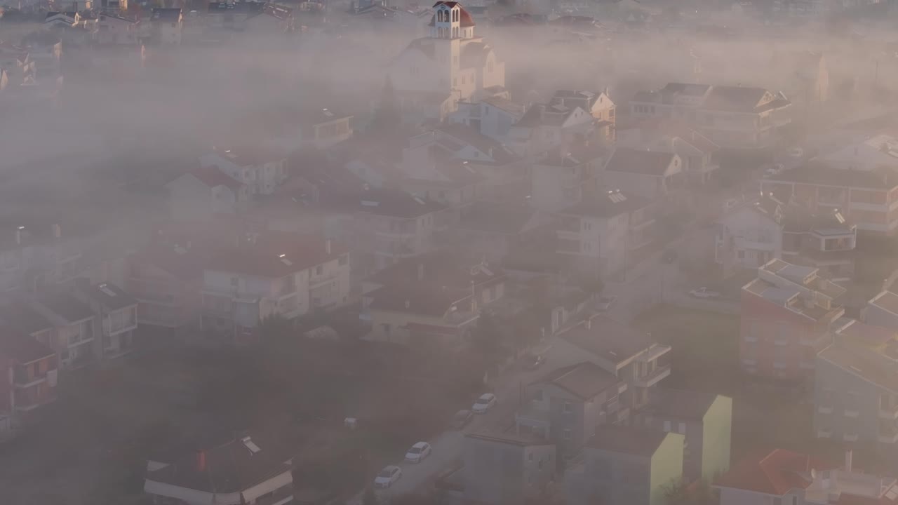 Vista drone di una città alle prime luci dell'alba con cime velate di nebbia sullo sfondo, Grecia