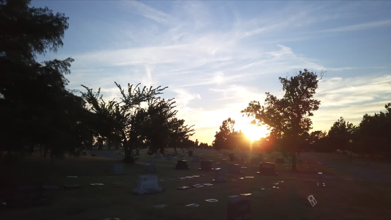 석양에 묘지를 통해 느린 공중 비행