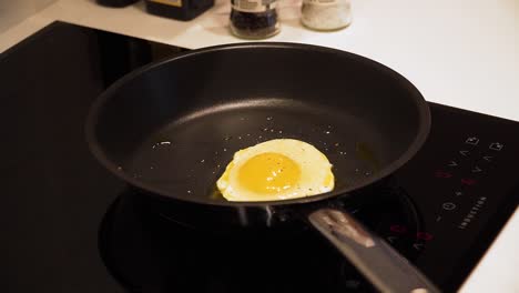 primer plano de cocinar huevo en una sartén para desayunar en la cocina