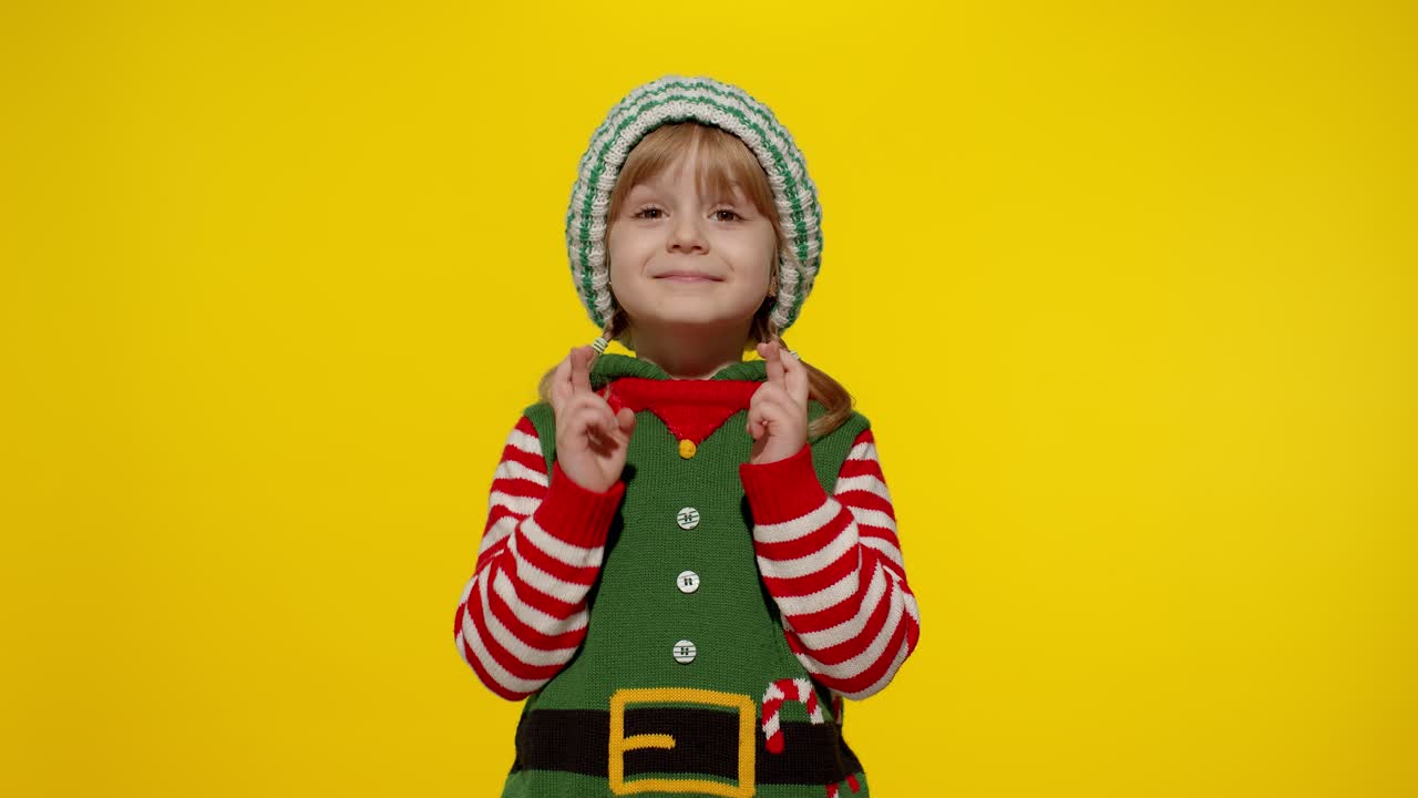 el concepto del deseo de navidad. niña adolescente en el disfraz de santa elf helper haciendo un deseo, reza