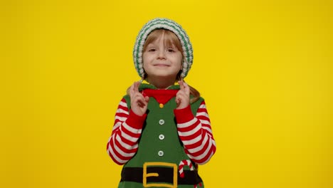 Christmas-wish-concept.-Kid-teen-girl-in-Christmas-elf-Santa-helper-costume-making-a-wish,-prays