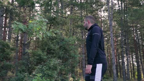 joven caminando por un bosque con árboles de hoja perenne