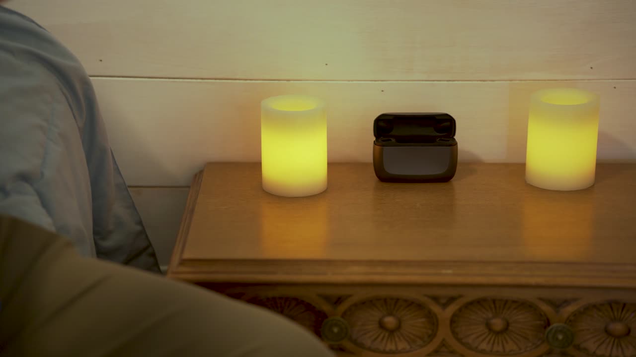 한 남자가 하루가 끝날 때 보청기를 충전 케이스에 넣습니다.