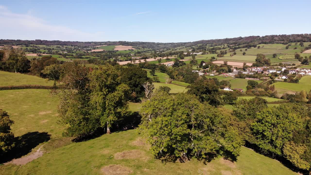 Aerial backward shot looking over trees and beautiful East Devon Countryside England