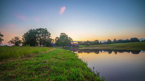 green riverbanks at sunrise with colorful sky reflecting on water surface