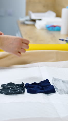 soft table laid with sheets prepared for newborn baby. little clothes are put on the table. vertical video