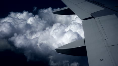 airplane wing above the dark clouds