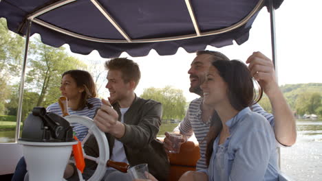 group of friends enjoying day out in boat on river together