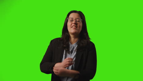 joven mujer de negocios con gafas hablando en el teléfono móvil contra el fondo del estudio de pantalla verde