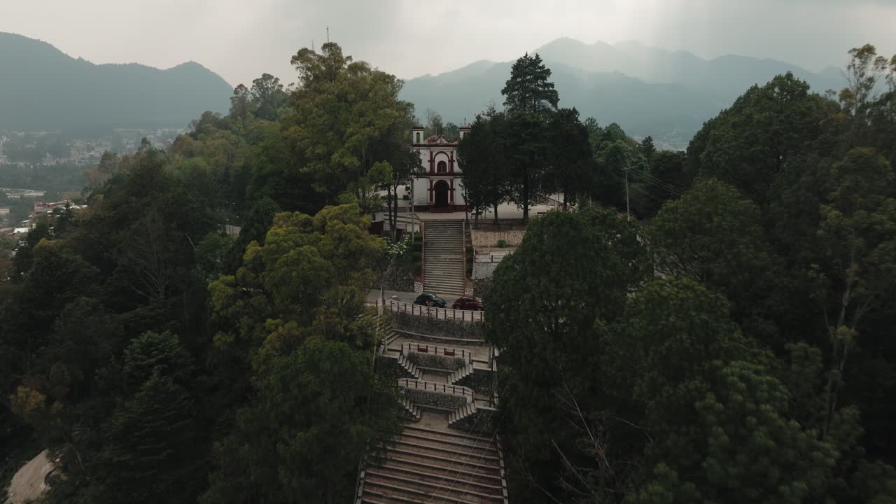 retiro sobre el templo de san cristobalito en la cima de una colina con árboles densos en san cristobal de las casas, chiapas, méxico
